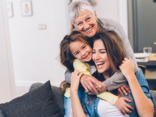 3 generations of women in a family hugging and smiling